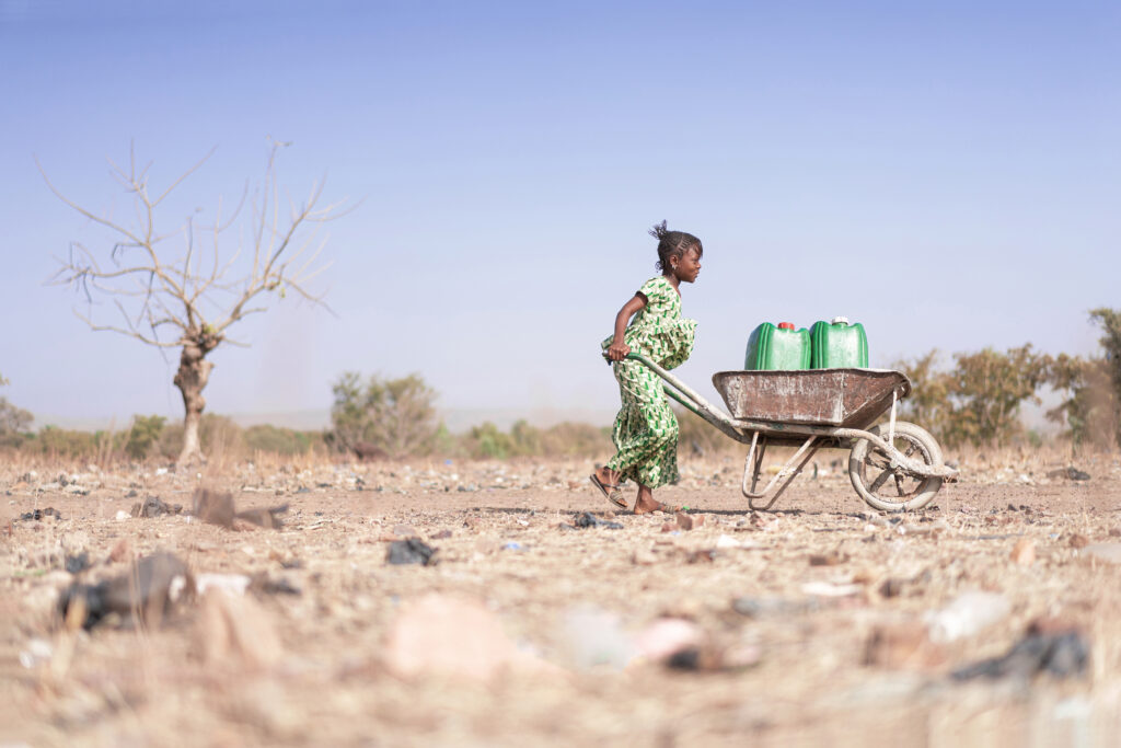 Little African Woman Transporting Fresh Water in a Drought - Water Crisis